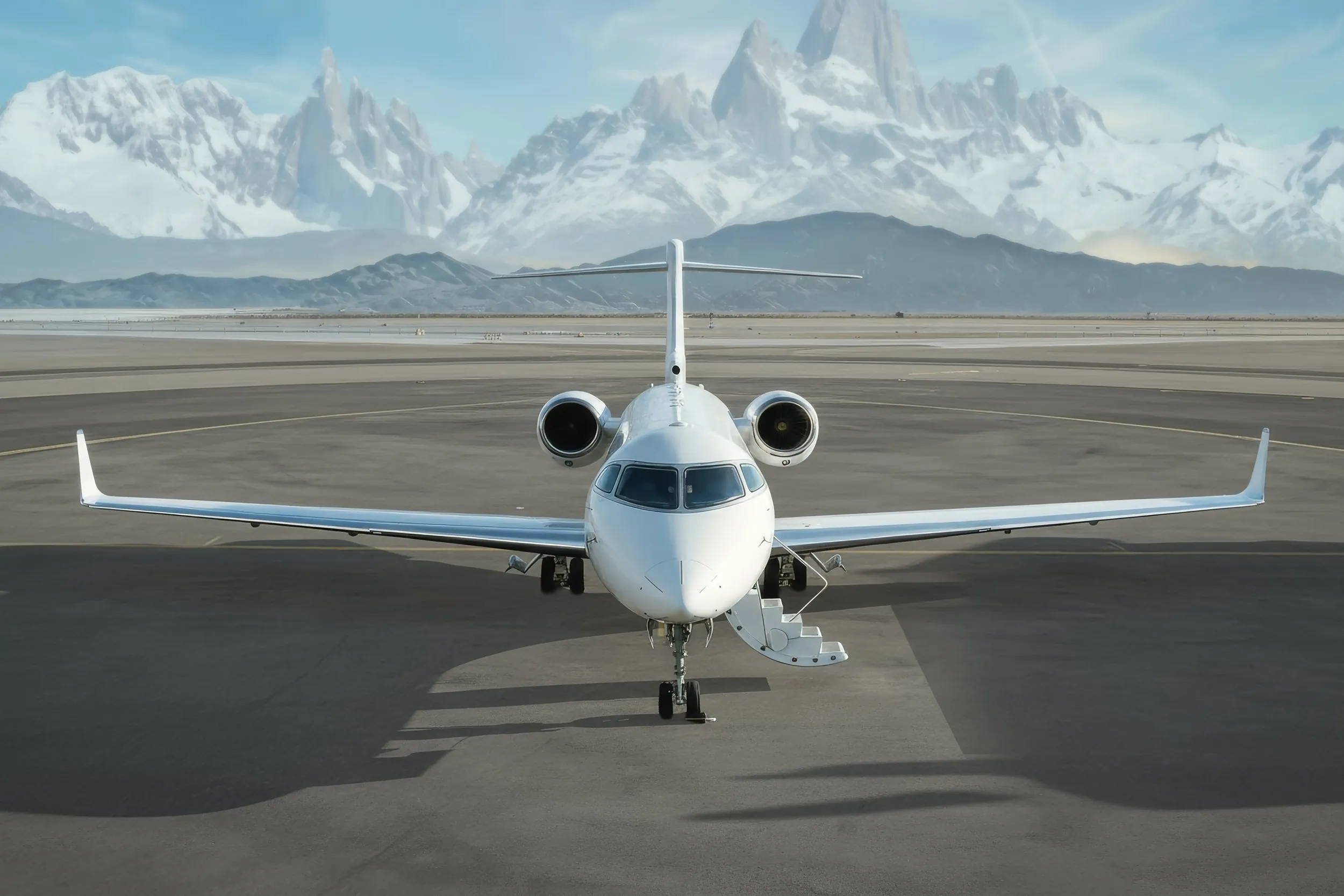 Jet privado en una pista con montañas nevadas al fondo