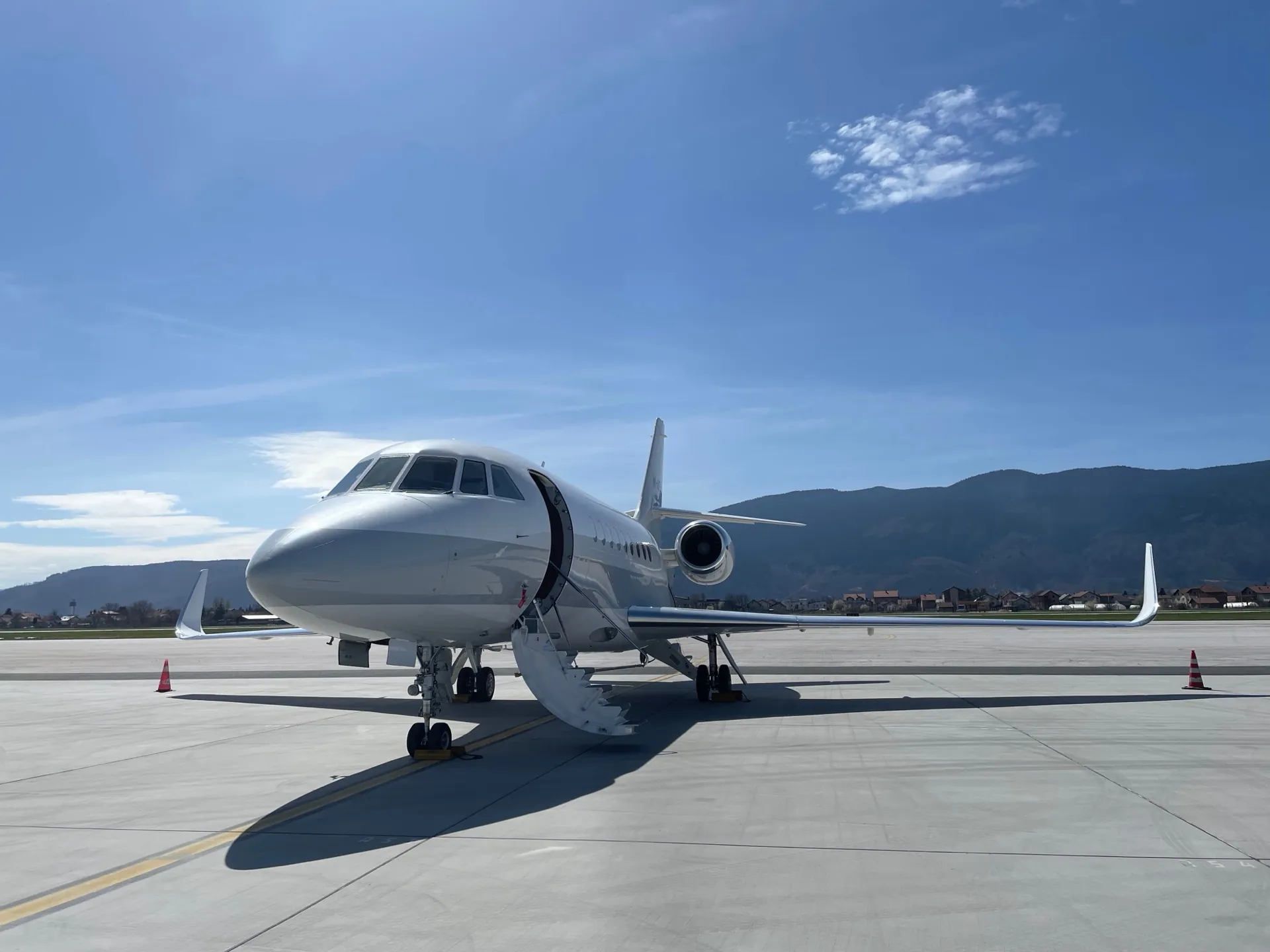 Un jet privado de PVJets estacionado en la pista con montañas al fondo