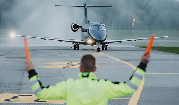 Jet privado de PVJets en la plataforma con un señalero de tierra