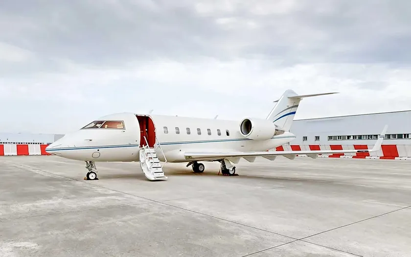 Jet privado Bombardier Challenger 650 aparcado en la pista con la escalerilla desplegada