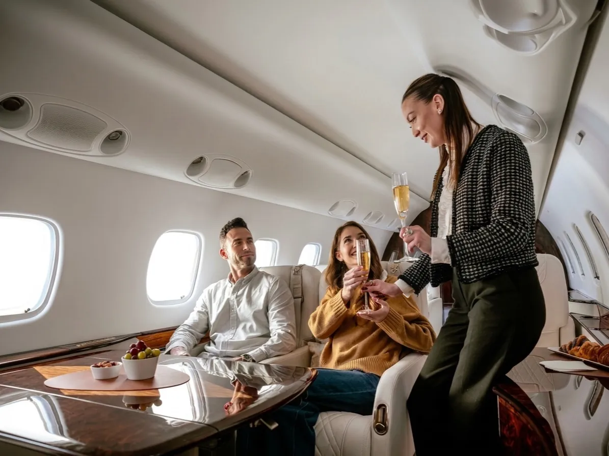Pasajeros brindando con champán en la cabina de un jet privado