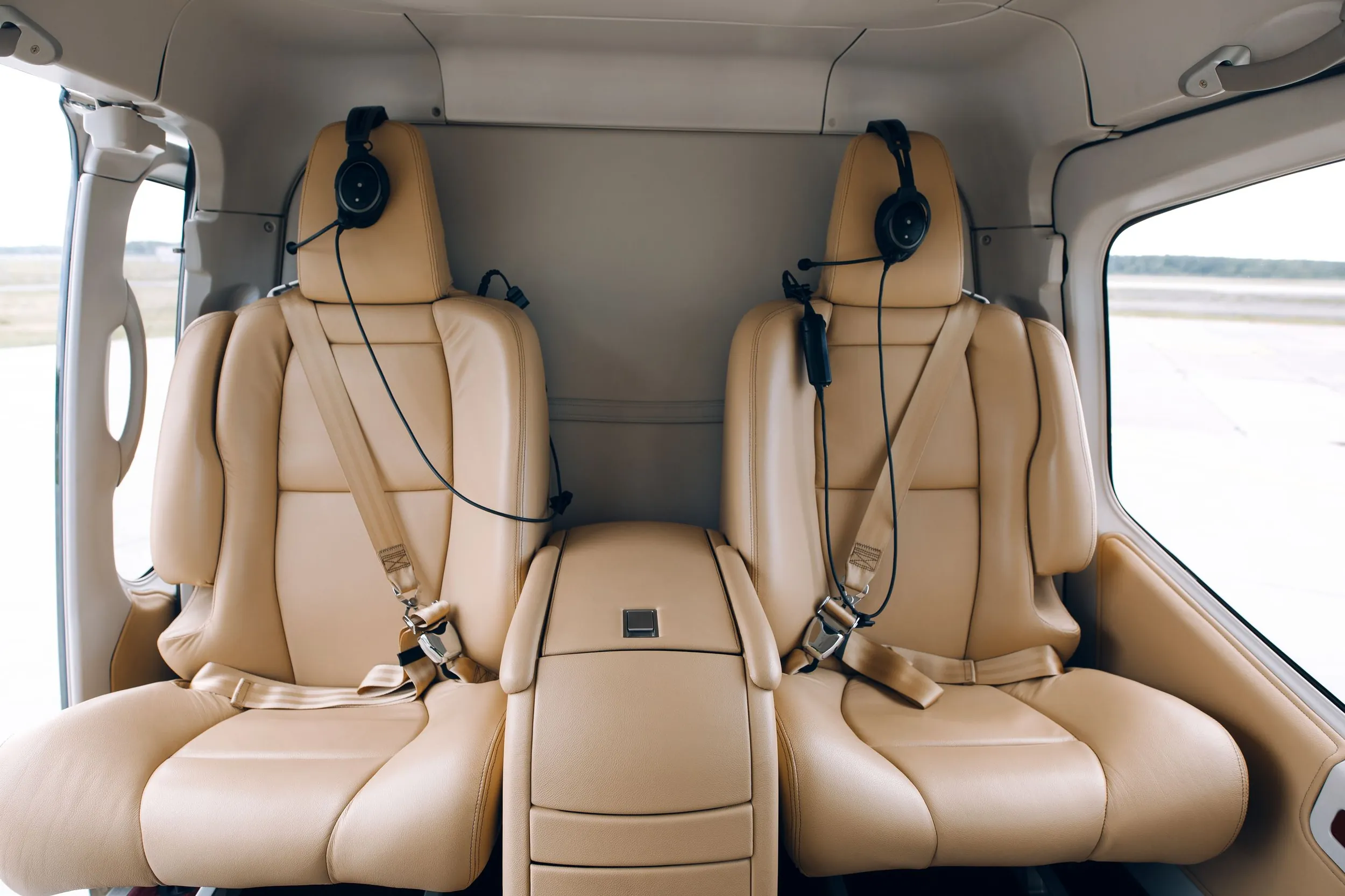 El interior de la cabina de piel color crema de un helicóptero privado