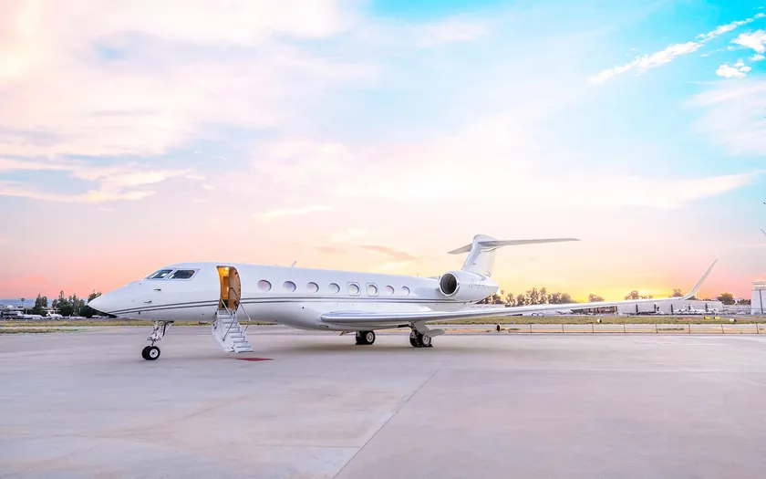Jet privado Gulfstream G650 aparcado en la pista al anochecer con la escalerilla desplegada