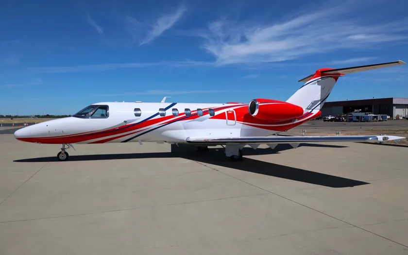 Jet privado Cessna Citation CJ4 Gen2 con librea roja y blanca aparcado en la plataforma