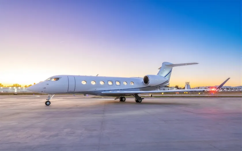 Jet privado Gulfstream G500 en la plataforma de un aeropuerto al atardecer