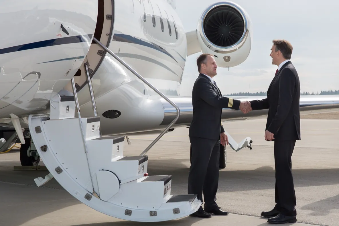 Un comandante de PVJets estrecha la mano de un cliente junto a un jet privado