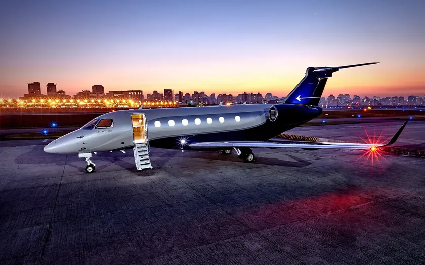 Jet privado Embraer Legacy 500 en la plataforma al atardecer, con la escalerilla desplegada