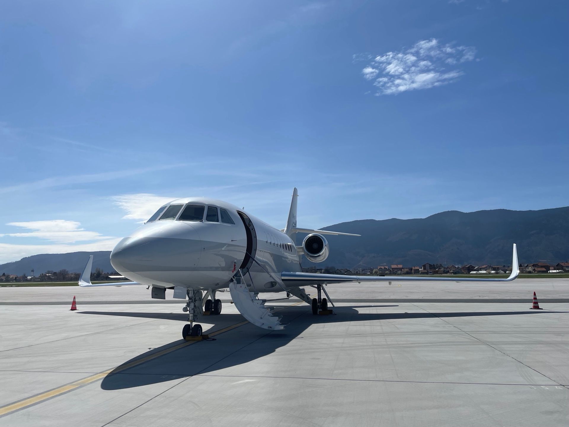 A PVJets private jet parked on the tarmac with mountains in the background
