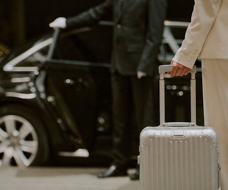 Chauffeur loading luggage into a luxury car