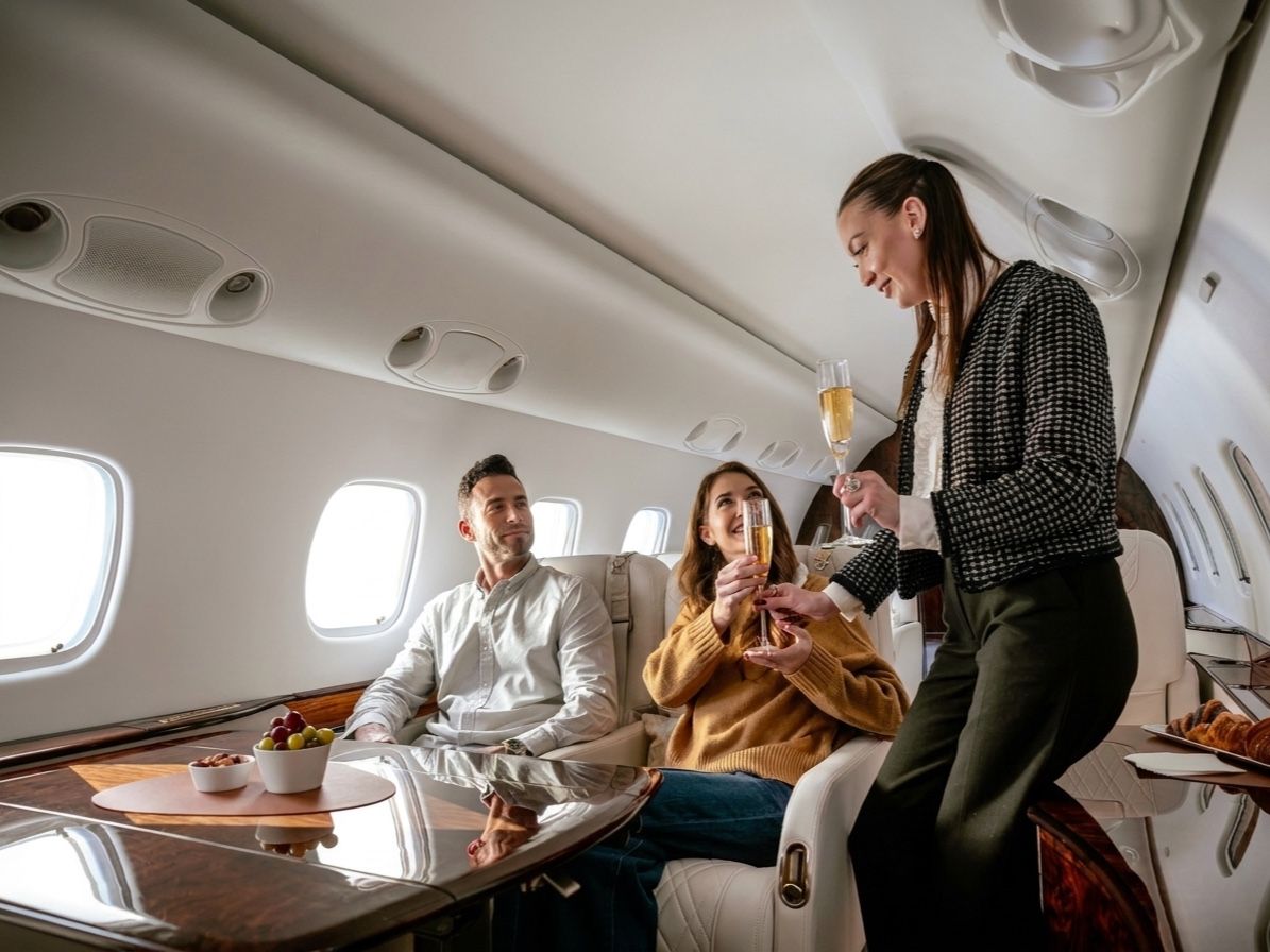 Passengers celebrating with champagne in a private jet cabin