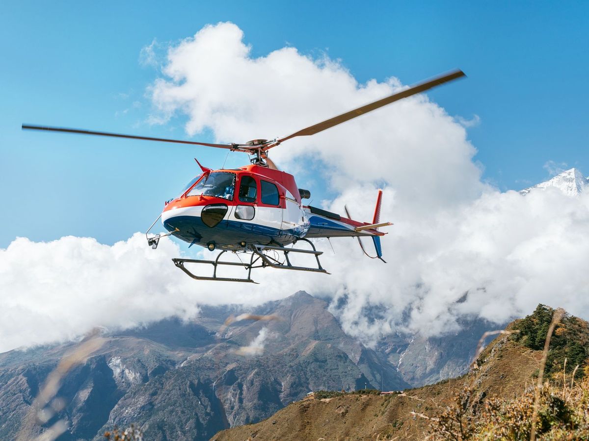 A helicopter flying over a remote mountain landscape
