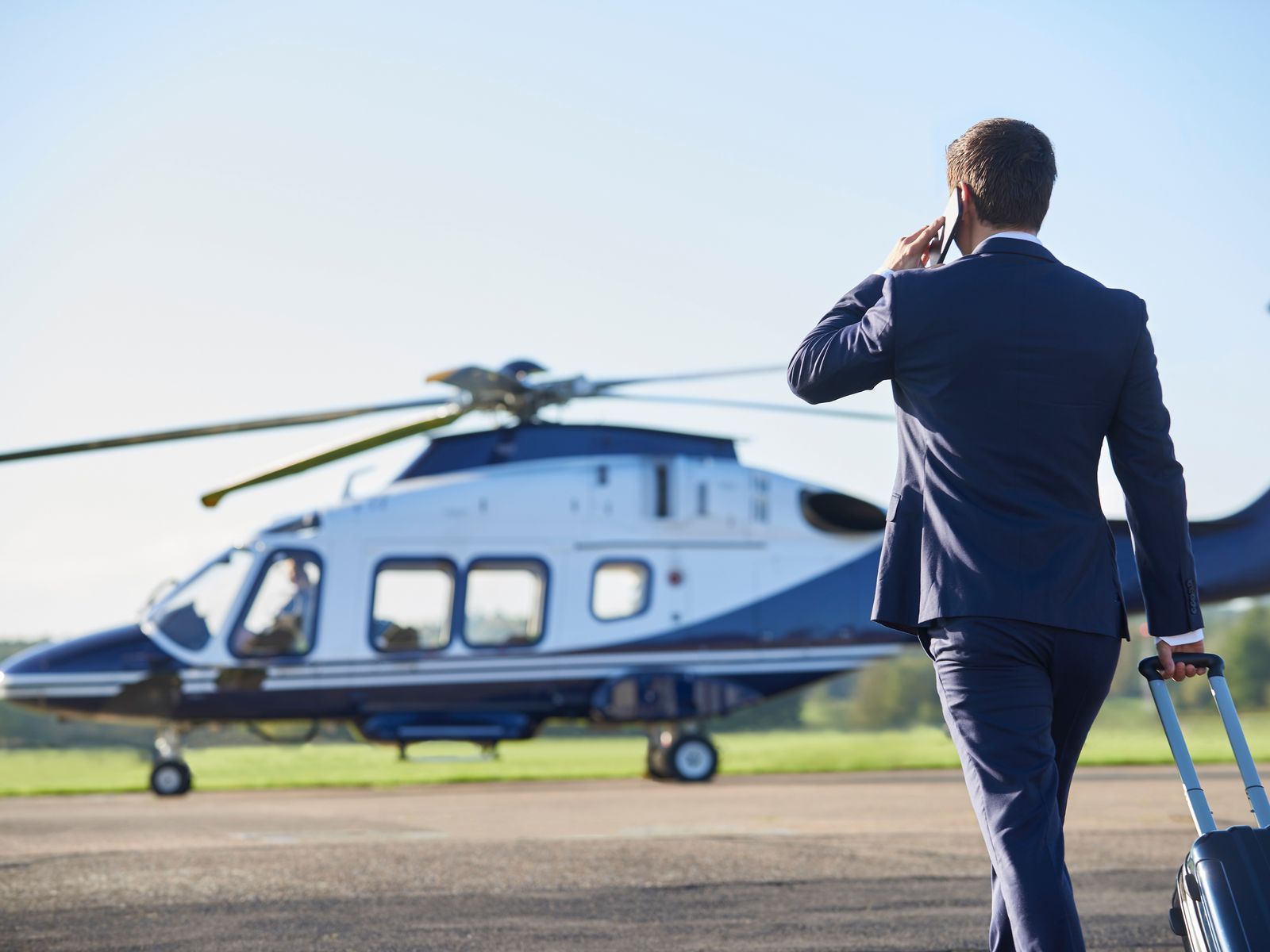 A business traveller walking to a waiting helicopter on the tarmac
