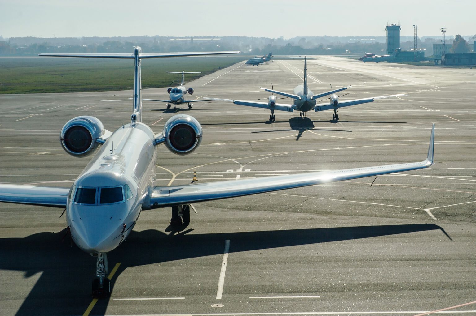 Private jets lined up on an airport apron